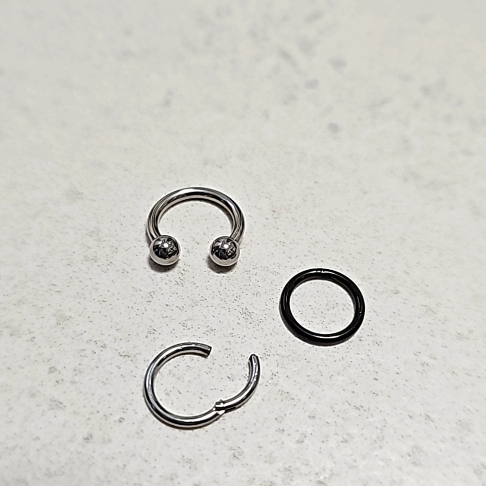 3 nose rings, 2 snap into place and 1 U-shaped ring